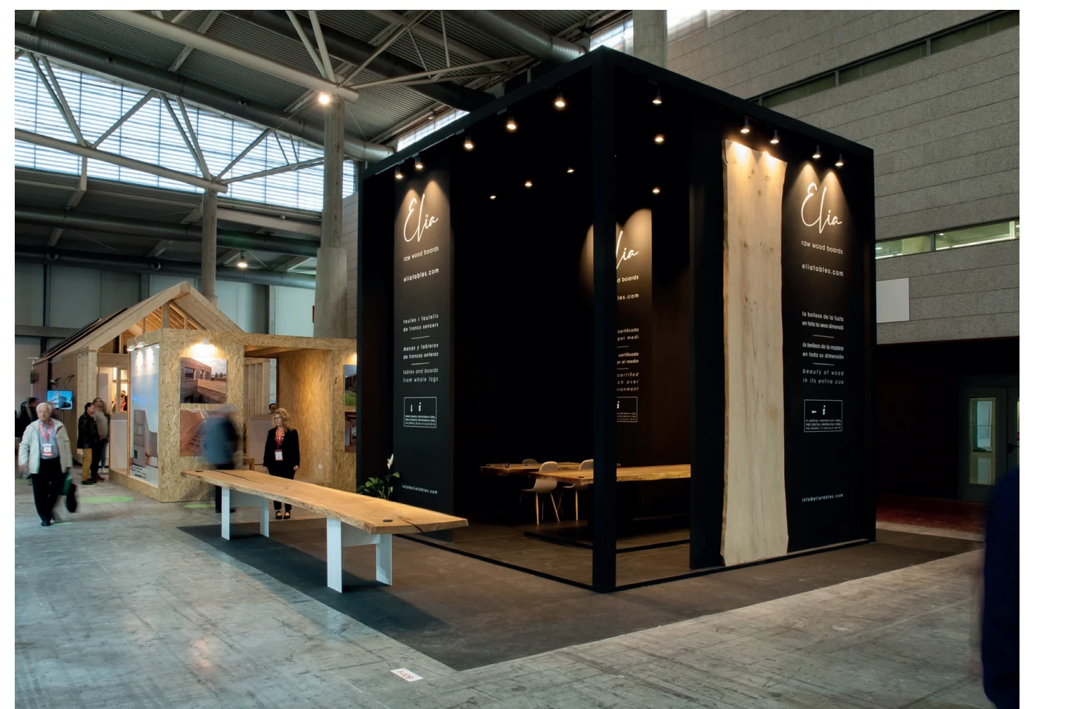 Fotografía de un stand de ELIA de paredes oscuras y mobiliario de madera